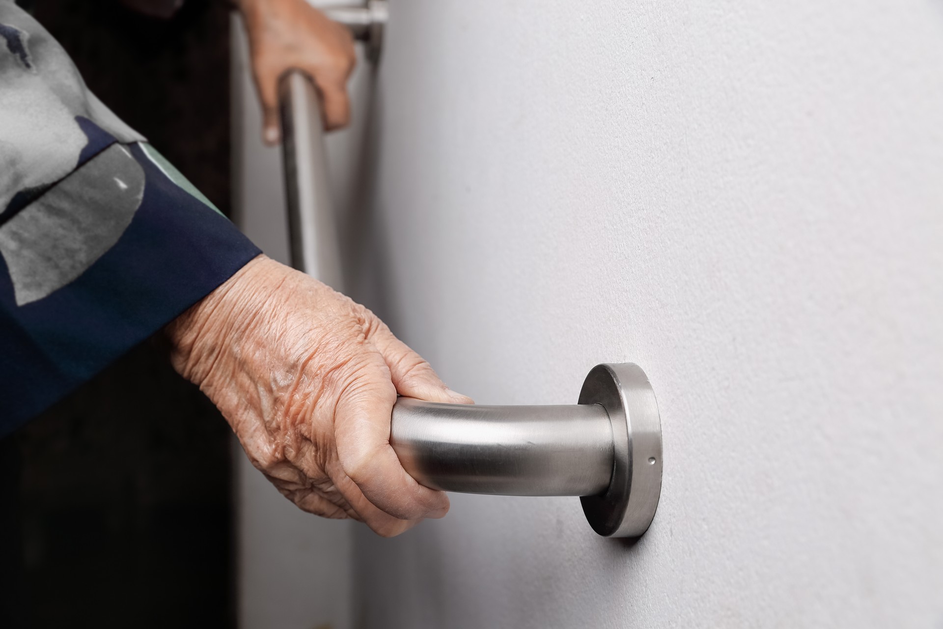 Elderly woman holding on handrail for safety walk steps