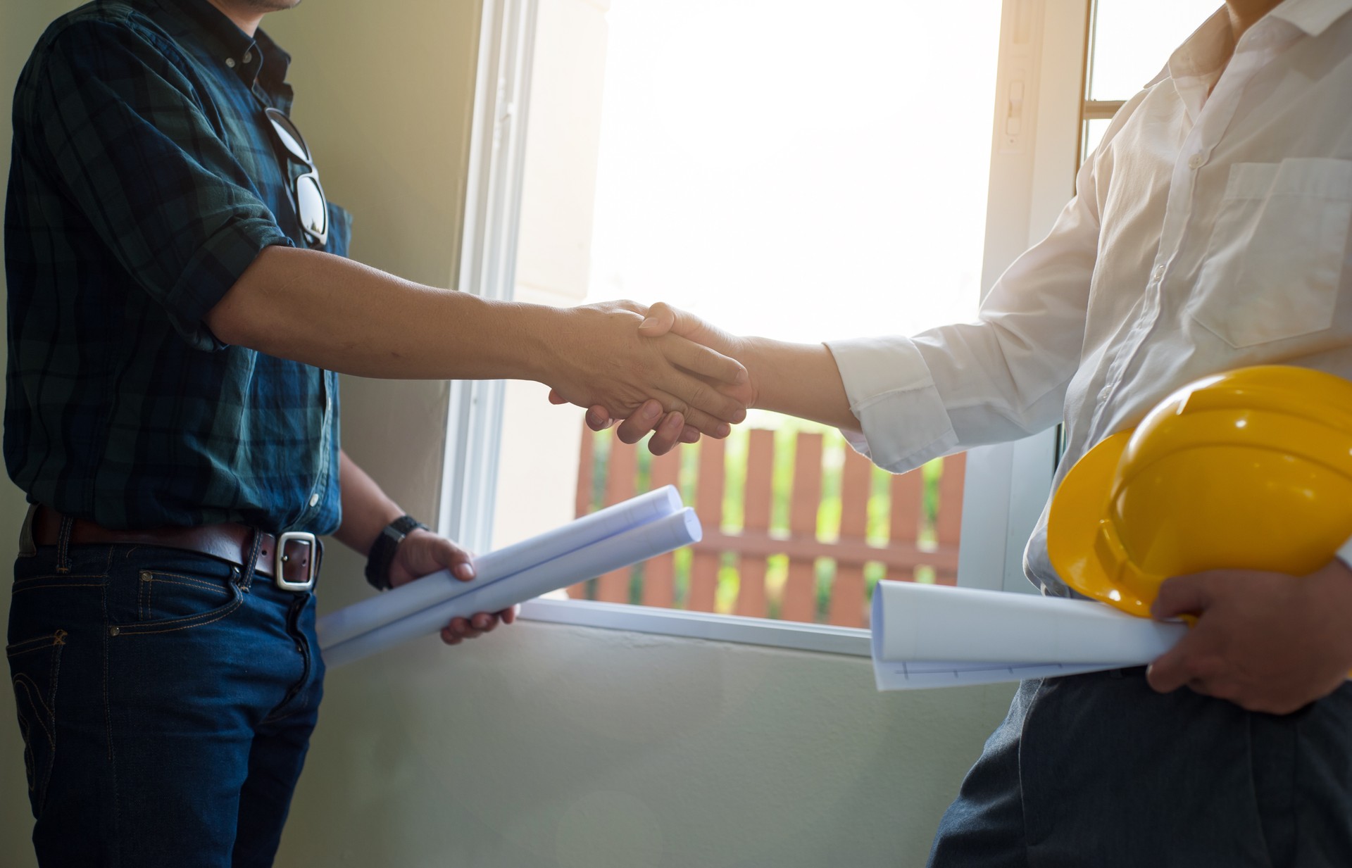 The architect inspector handshake with the contractor after completing the construction project.