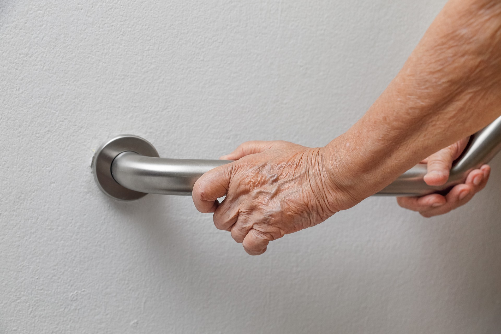 Elderly woman holding on handrail for safety walk steps